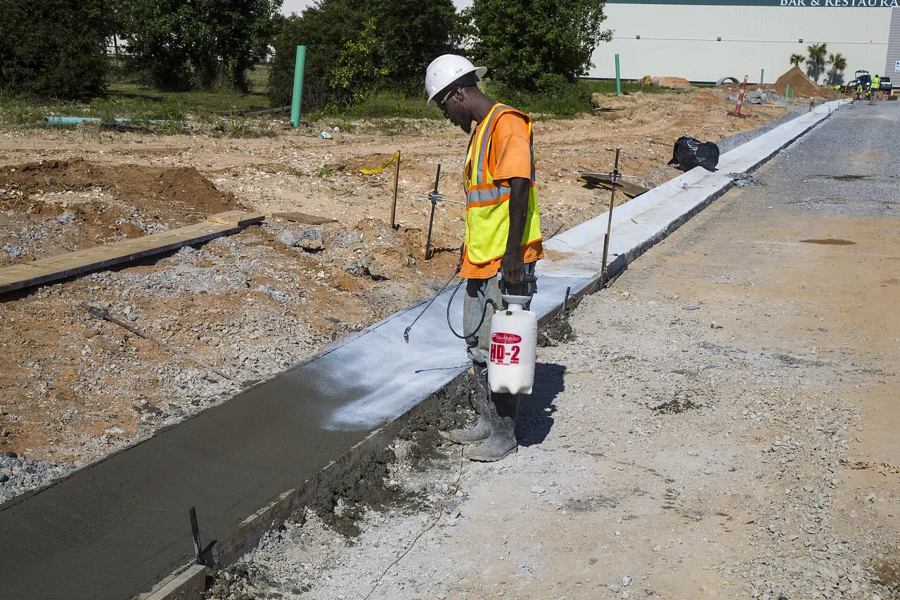 A worker finishes a new curb on a Biloxi street after water lines were replaced. It does not show work tied to this rate change.