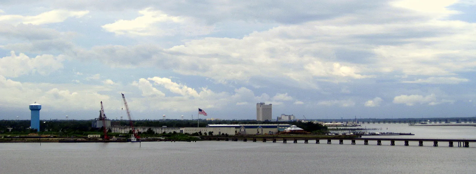 The mouth of the Back Bay of Biloxi seen from the U.S. 90 bridge, with the East Biloxi waterfront and a Biloxi water tower beyond.