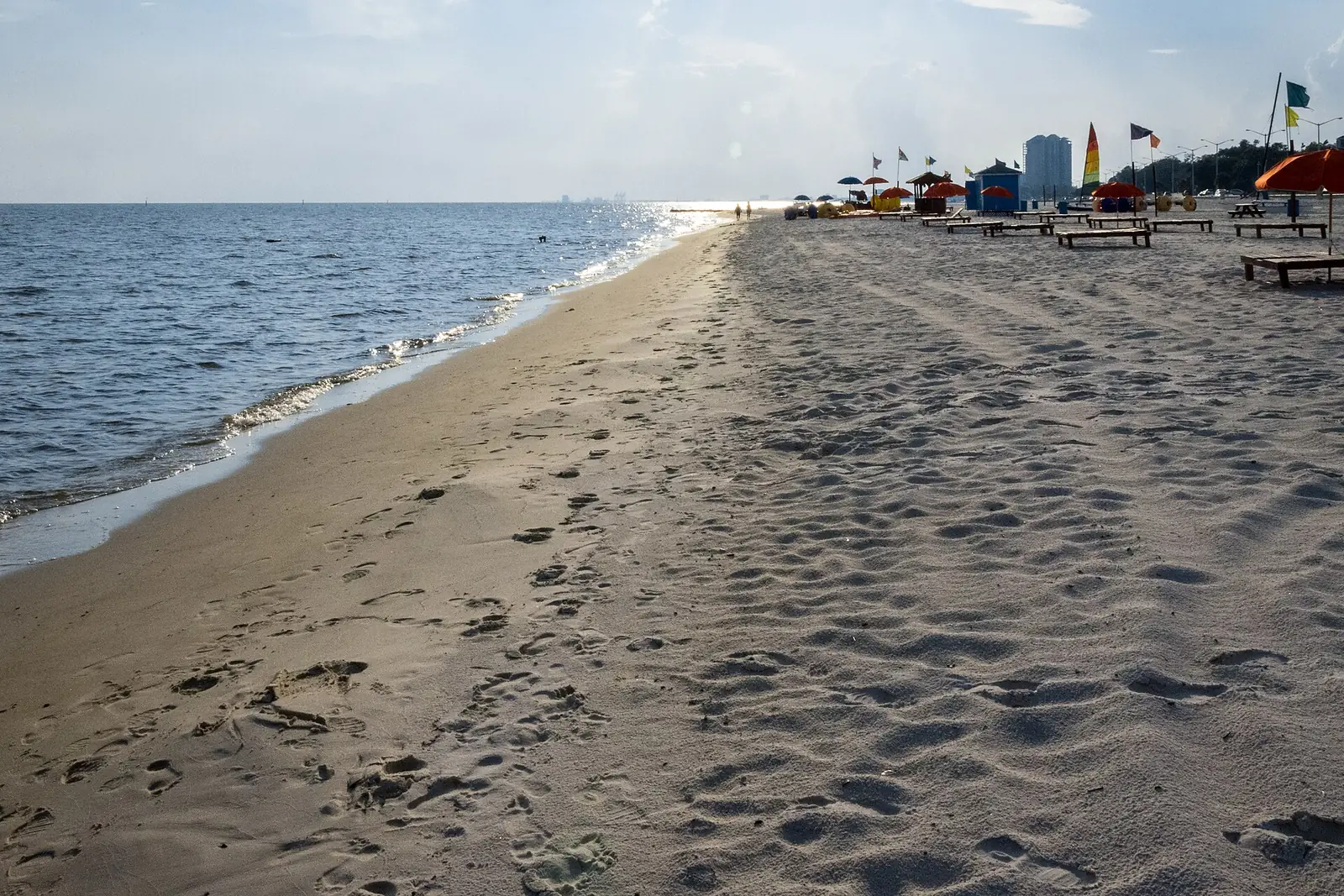 Beach umbrellas and chairs on the white sand along the Mississippi Sound in Biloxi.