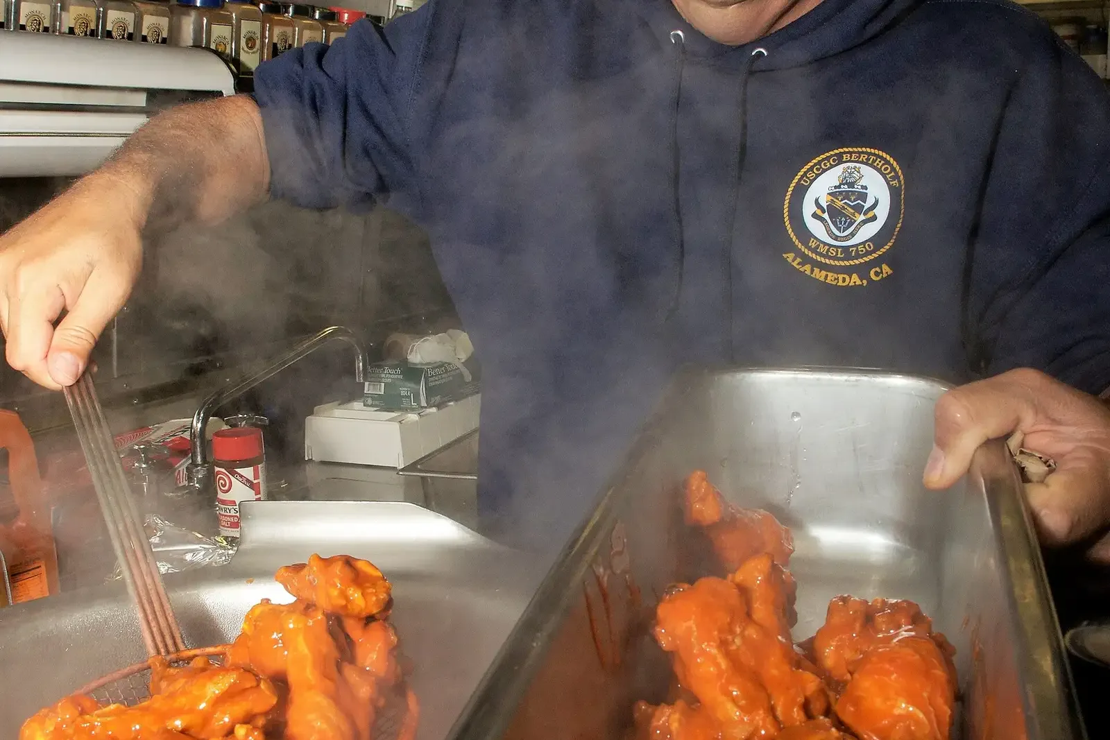 A tray of Buffalo chicken wings tossed in sauce, prepared in the galley of a U.S. Coast Guard cutter.
